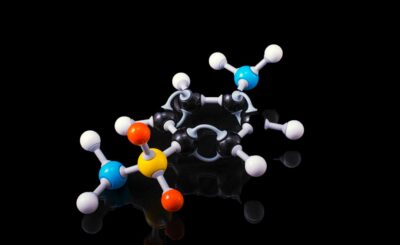 A molecular model representing peptide structure with colored atoms against a black background.