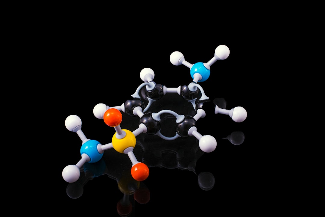A molecular model representing peptide structure with colored atoms against a black background.